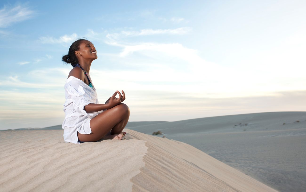 woman sat in easy pose in the sand