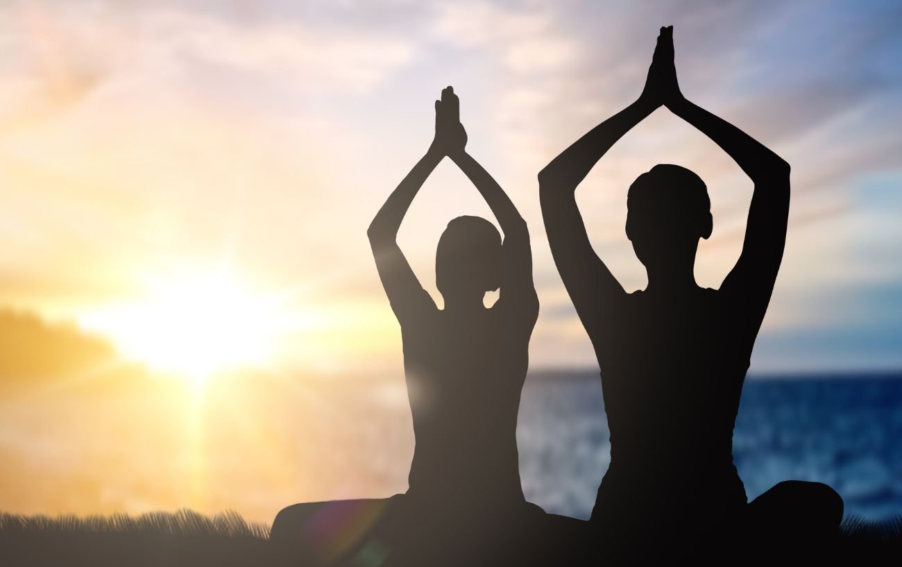 people doing yoga by the sea