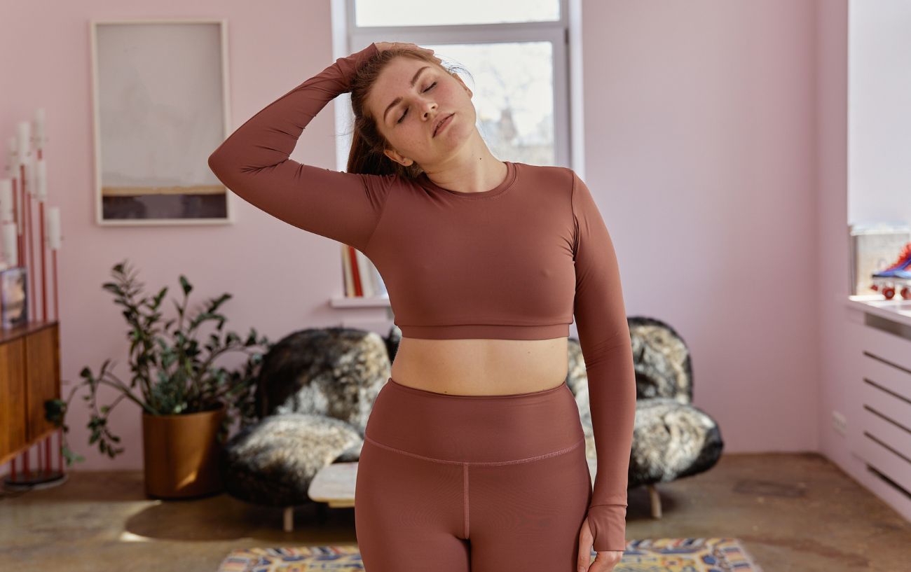 a woman in her living room wearing yoga clothes doing yoga