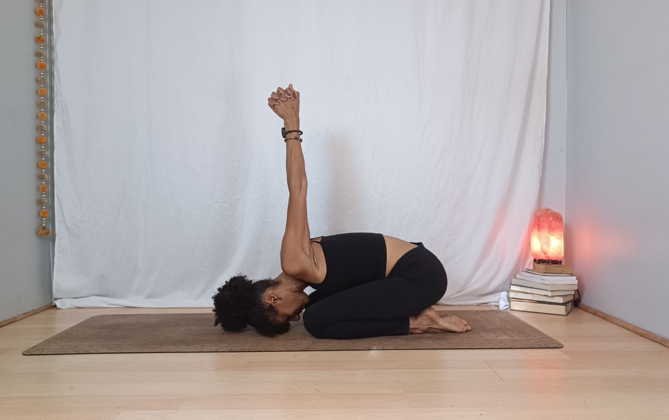 a woman doing child's pose with a bind