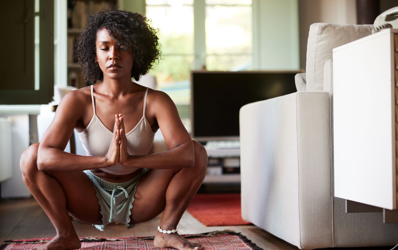 a woman doing a deep yoga squat in a living room