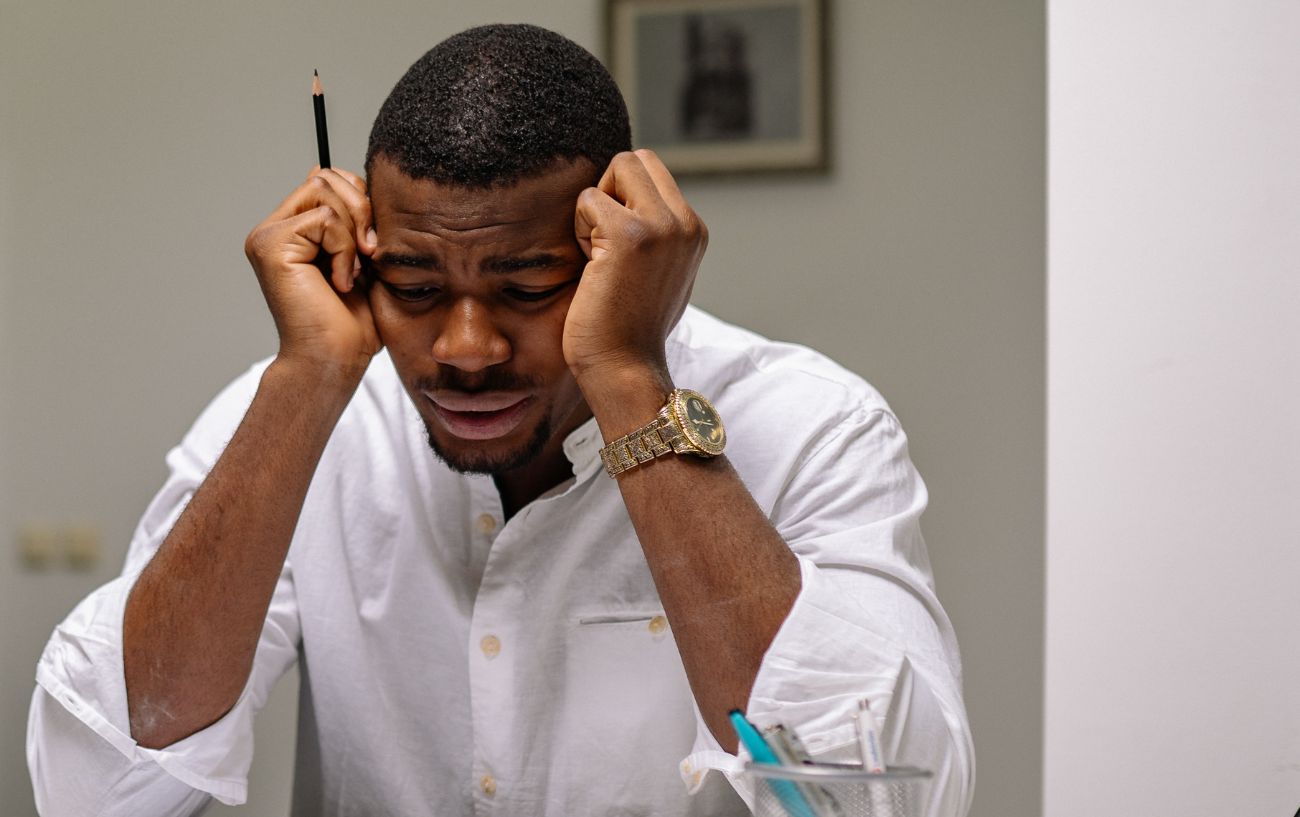 man stressed with his head on his temples