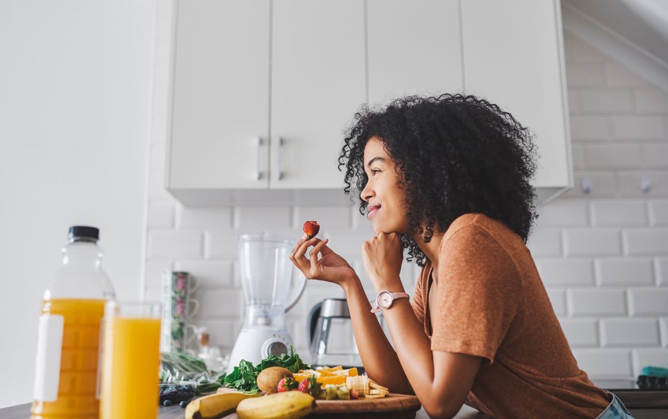 lady eating food in her kitchen smiling