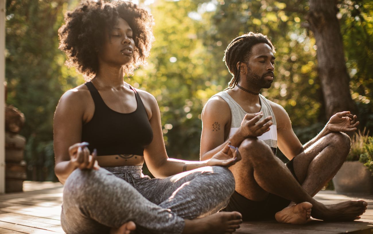 man and woman sat in sukhasana/easy pose meditating