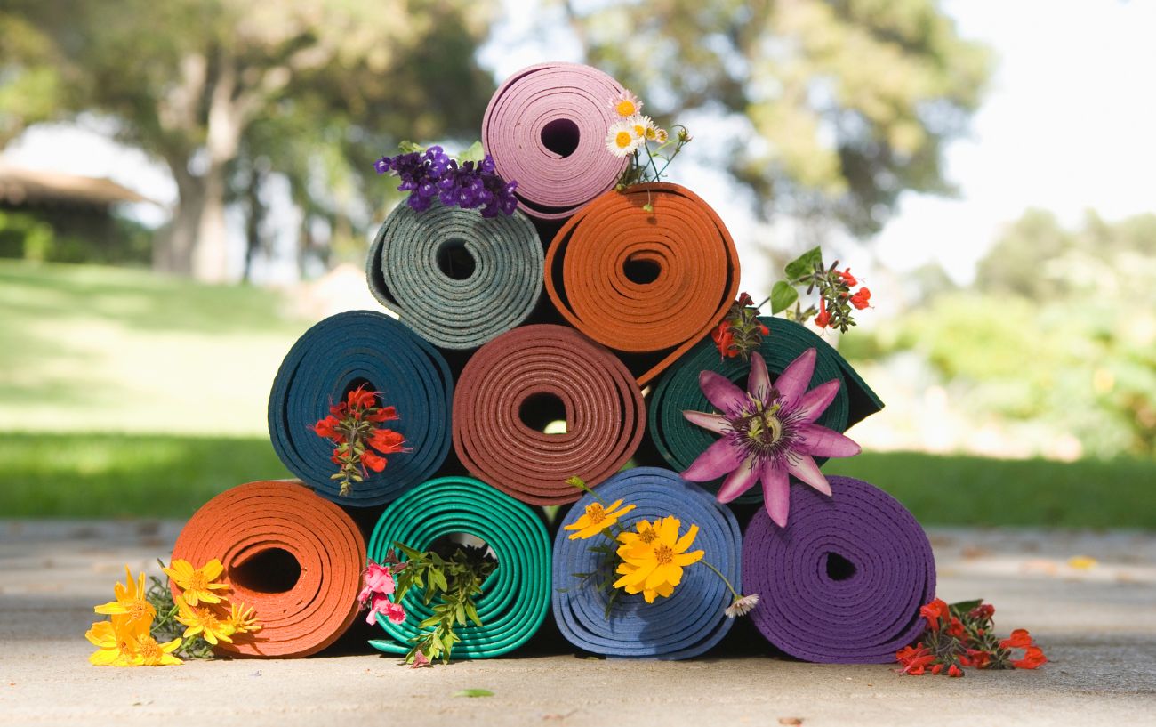 yoga mat pile with flowers over them