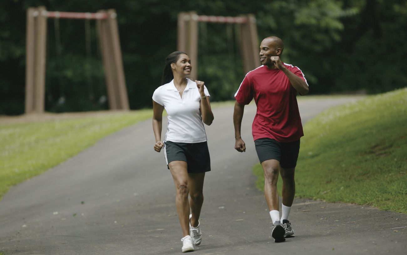 man and woman jogging through a park