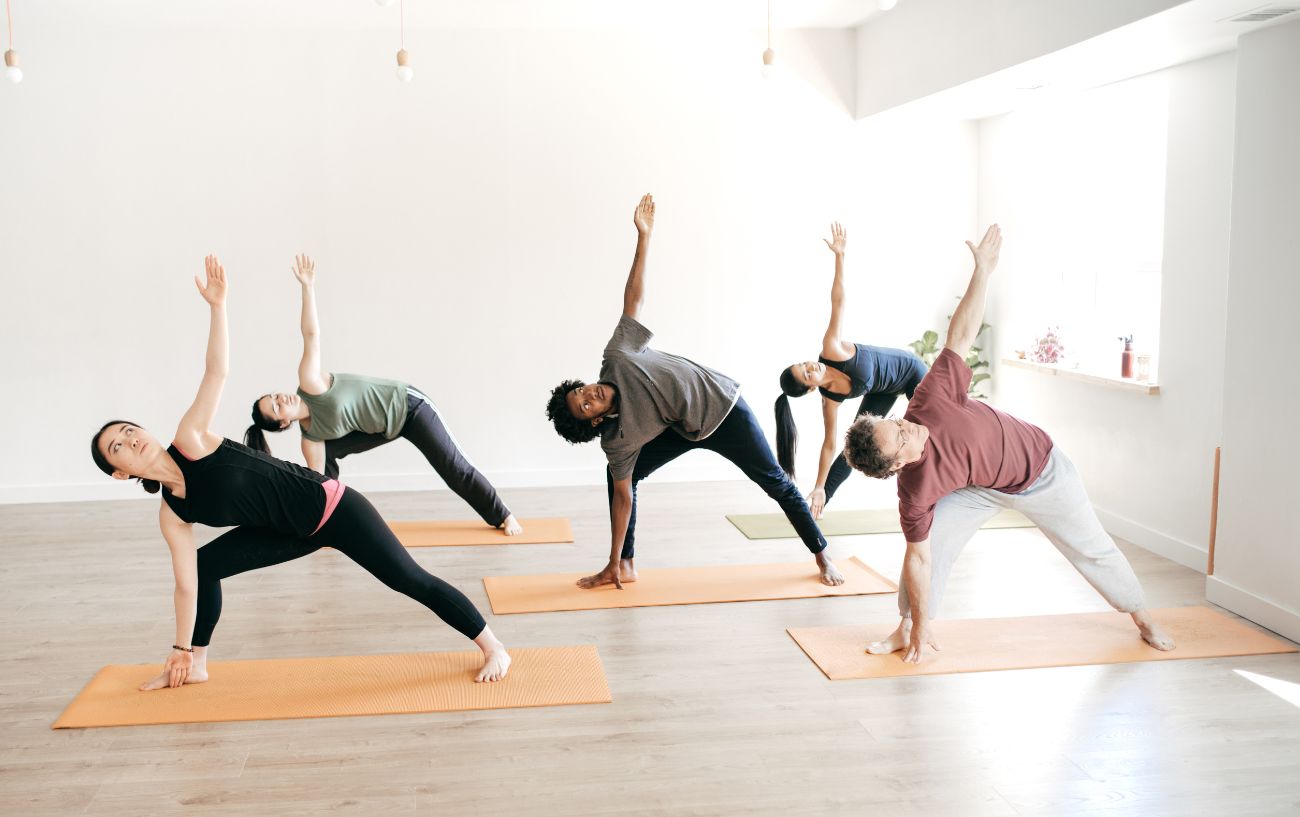 people in a yoga class doing trikonasana modified