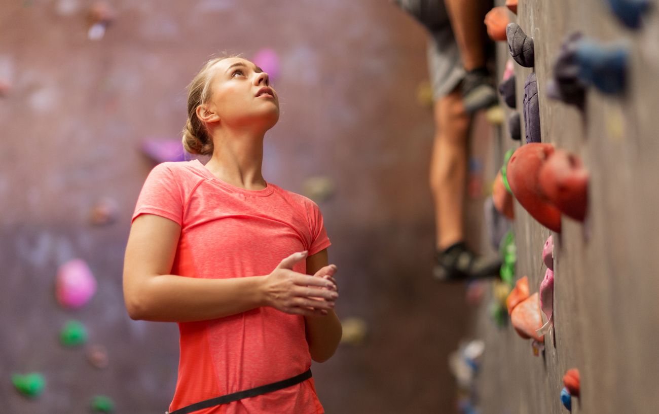 woman looking up at a indoor climbing wall