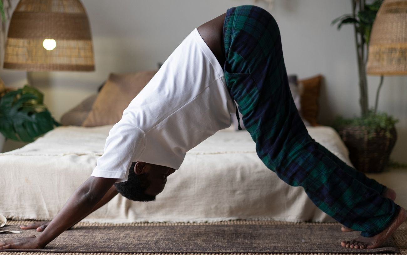 man doing yoga for high blood pressure in his bedroom