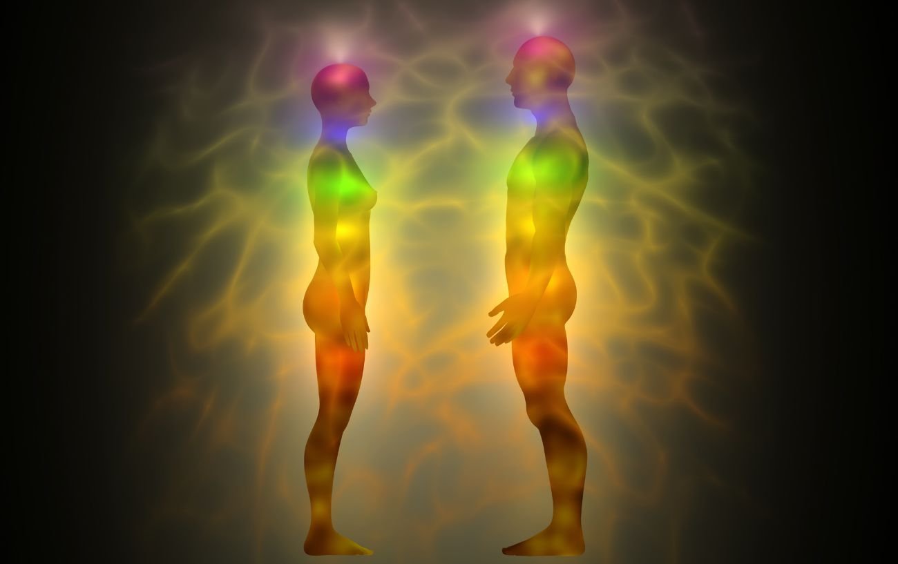 two people with rainbow or chakra coloured energy emanating from their bodies