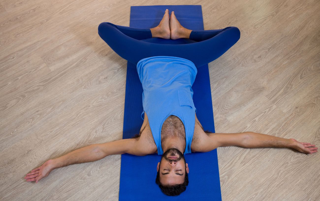 man in reclined bound angle pose