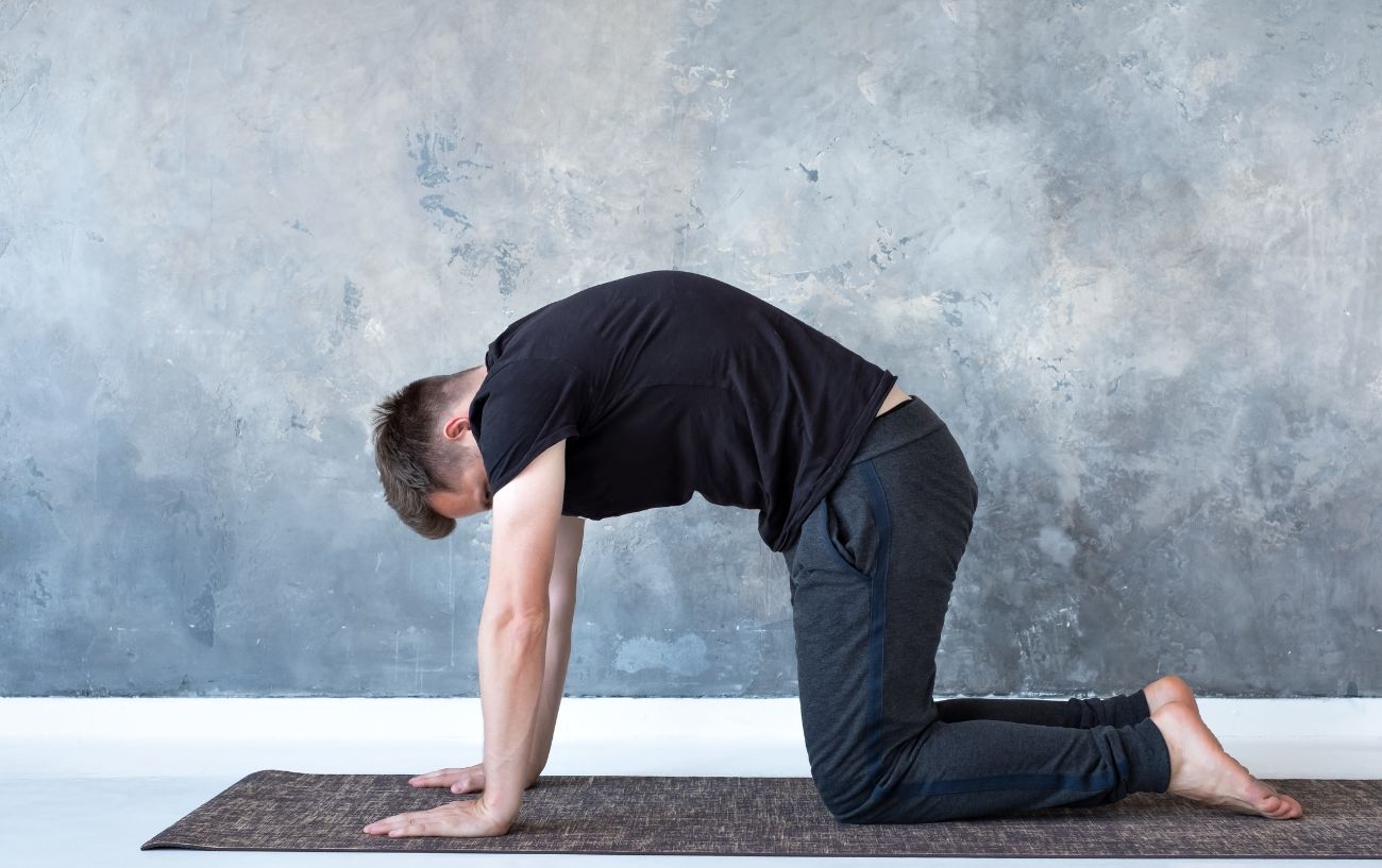 man doing yoga cat cow pose