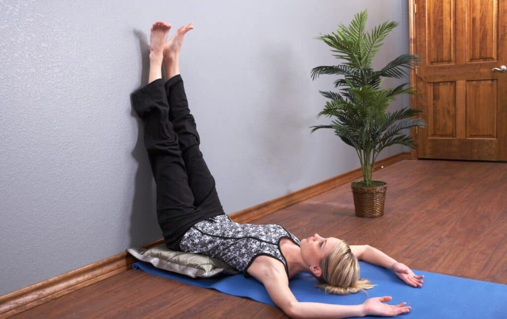 a woman doing a legs up the wall pose