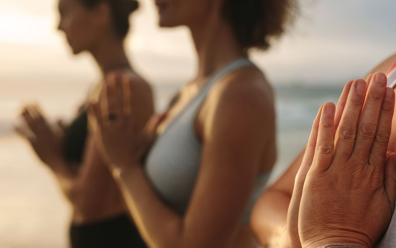 people stood in a row with hands in anjali mudra