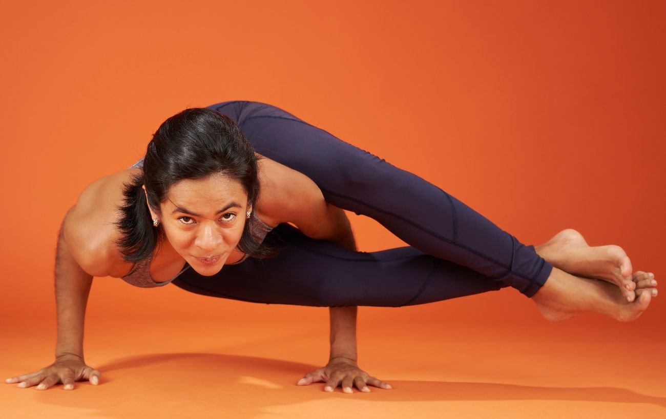 woman doing advanced yoga poses - eight angle pose