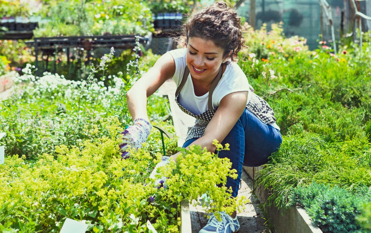 a woman crouching down and gardening