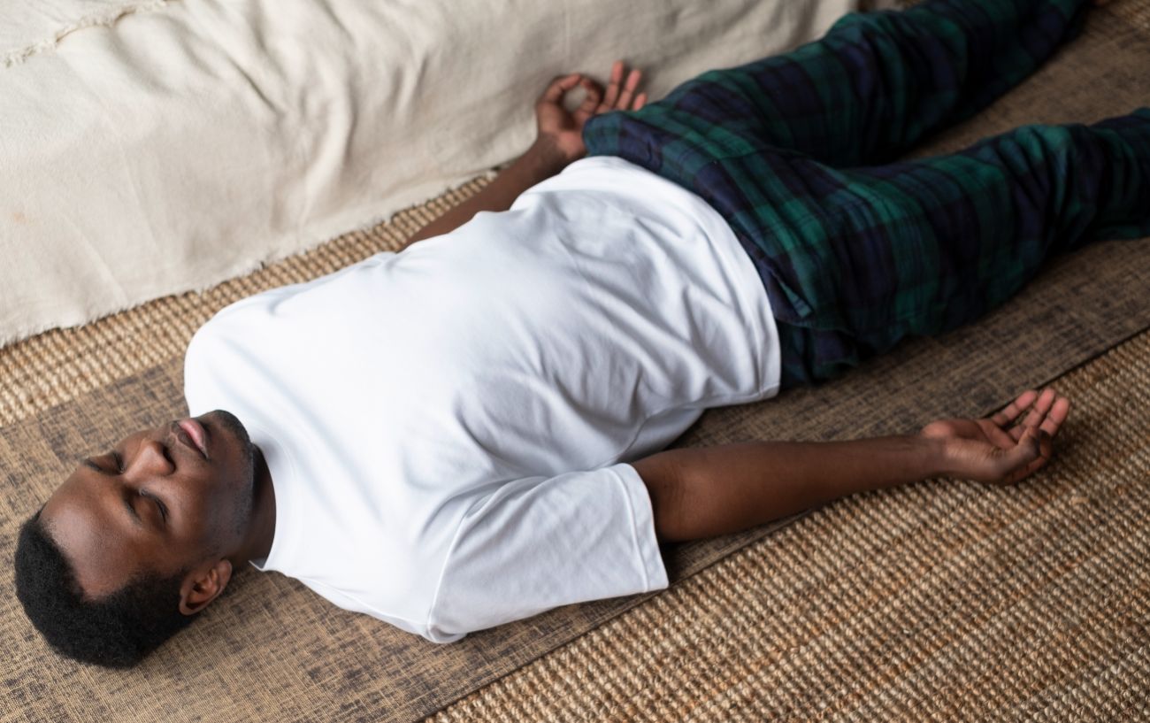 man lying on a mat in savasana