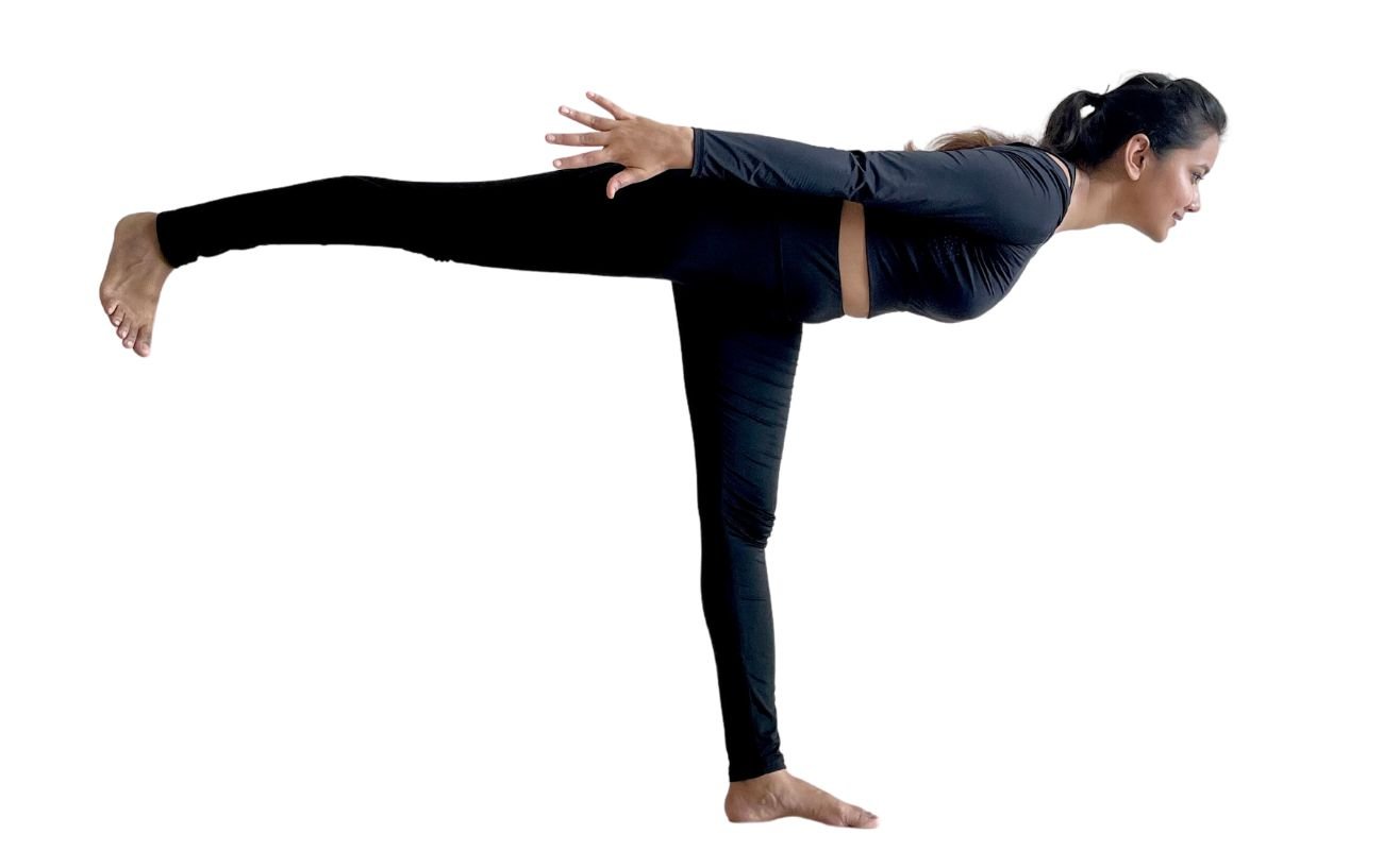 a woman wearing black yoga clothes doing airplane pose