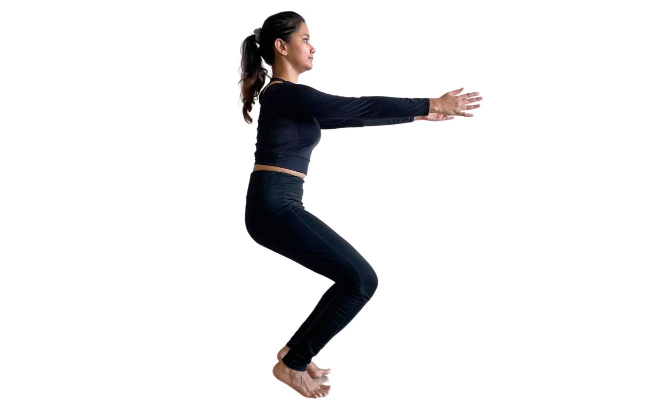 a woman wearing black yoga clothes doing awkward pose