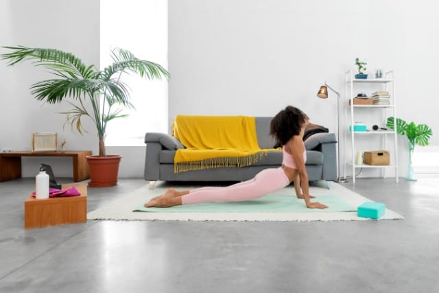 a woman doing cobra pose in her living room