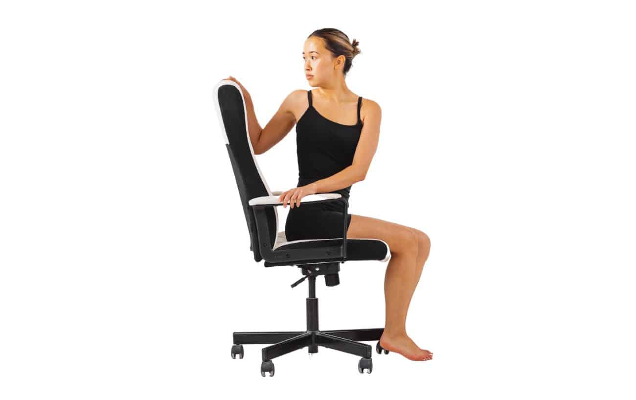 a woman doing Bharadvaja’s Twist on a chair