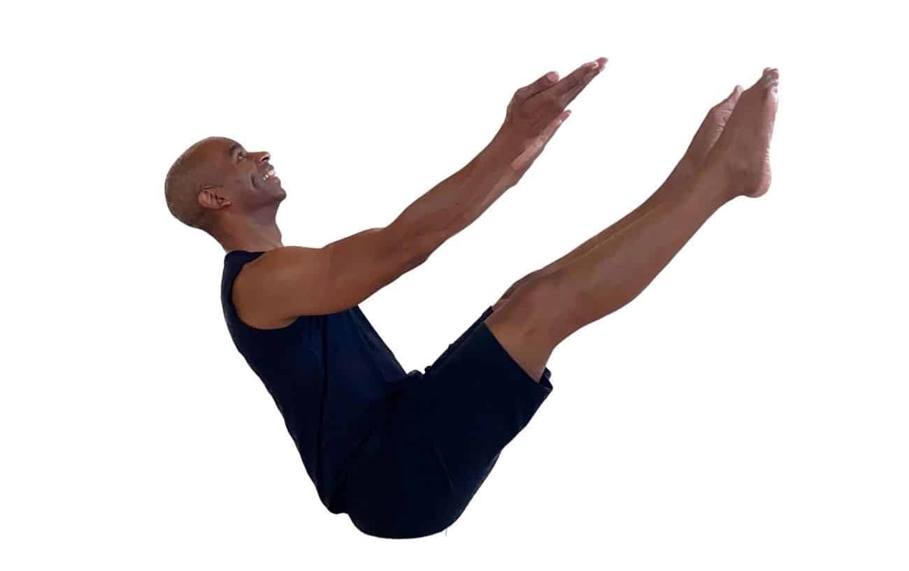 a man wearing black doing boat pose (navasana) with his legs extended