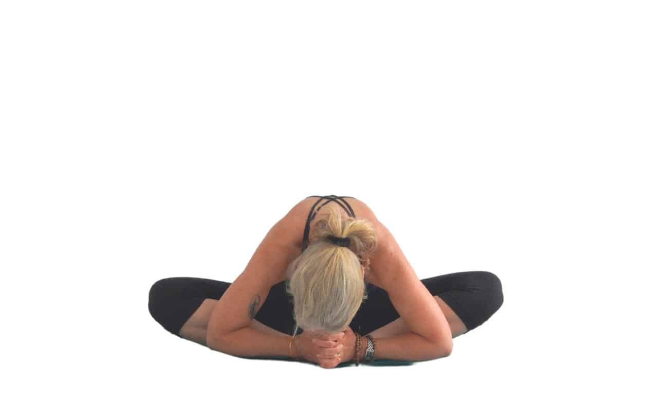 woman doing a bound angle pose with a forward bend