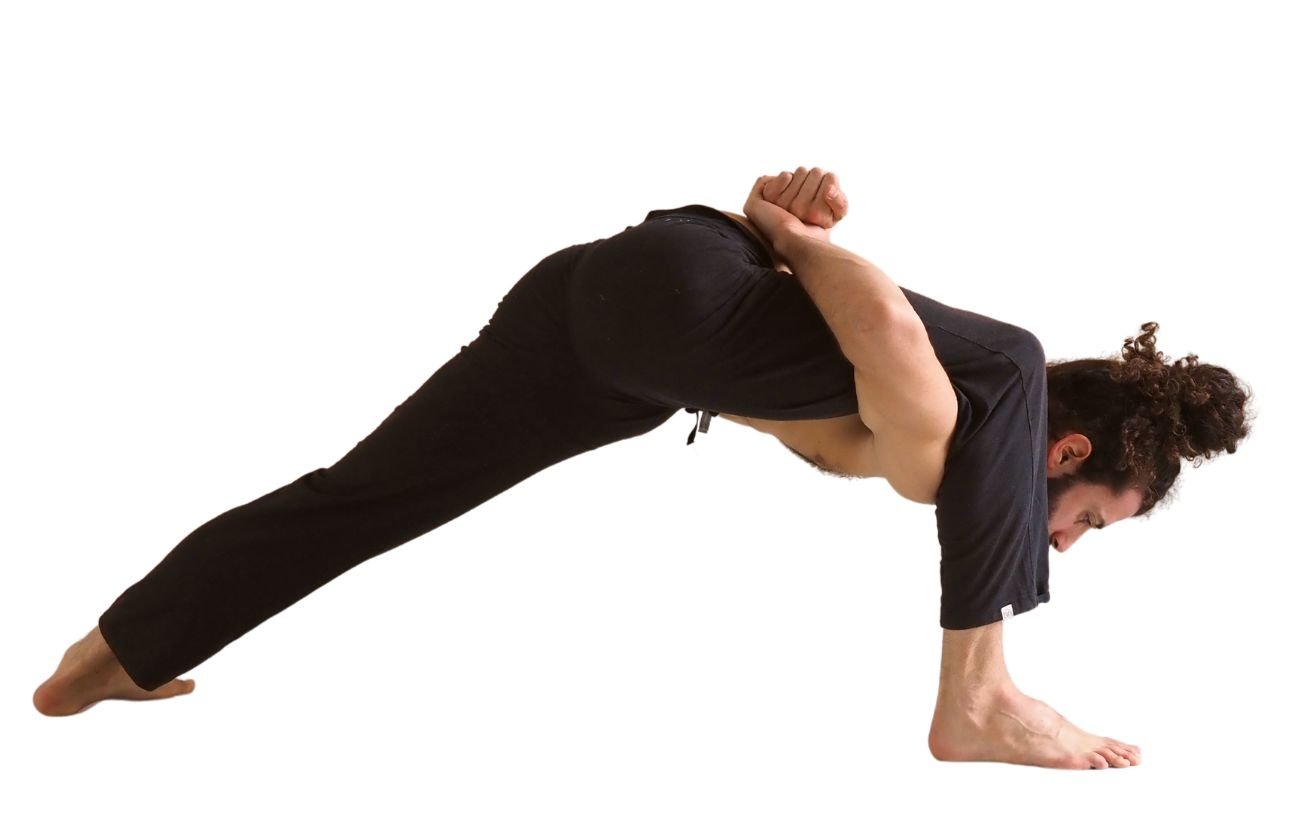 a man wearing black yoga trousers doing humble warrior pose with a bind