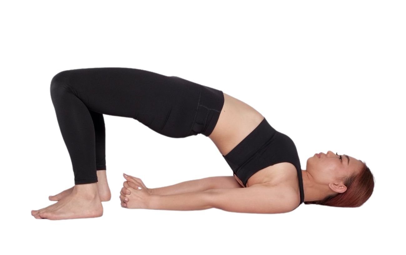 a woman wearing black yoga clothes in bridge pose