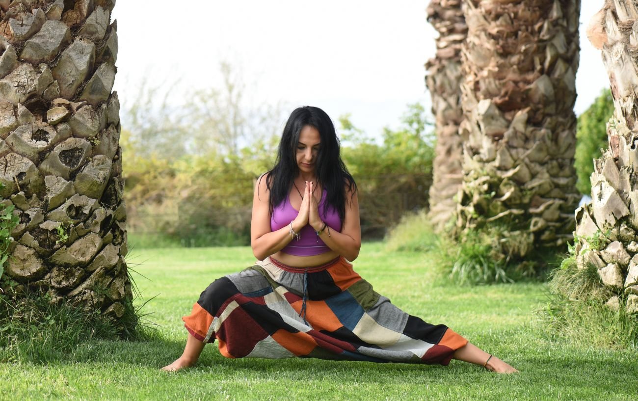 A woman doing yoga without a mat outside.