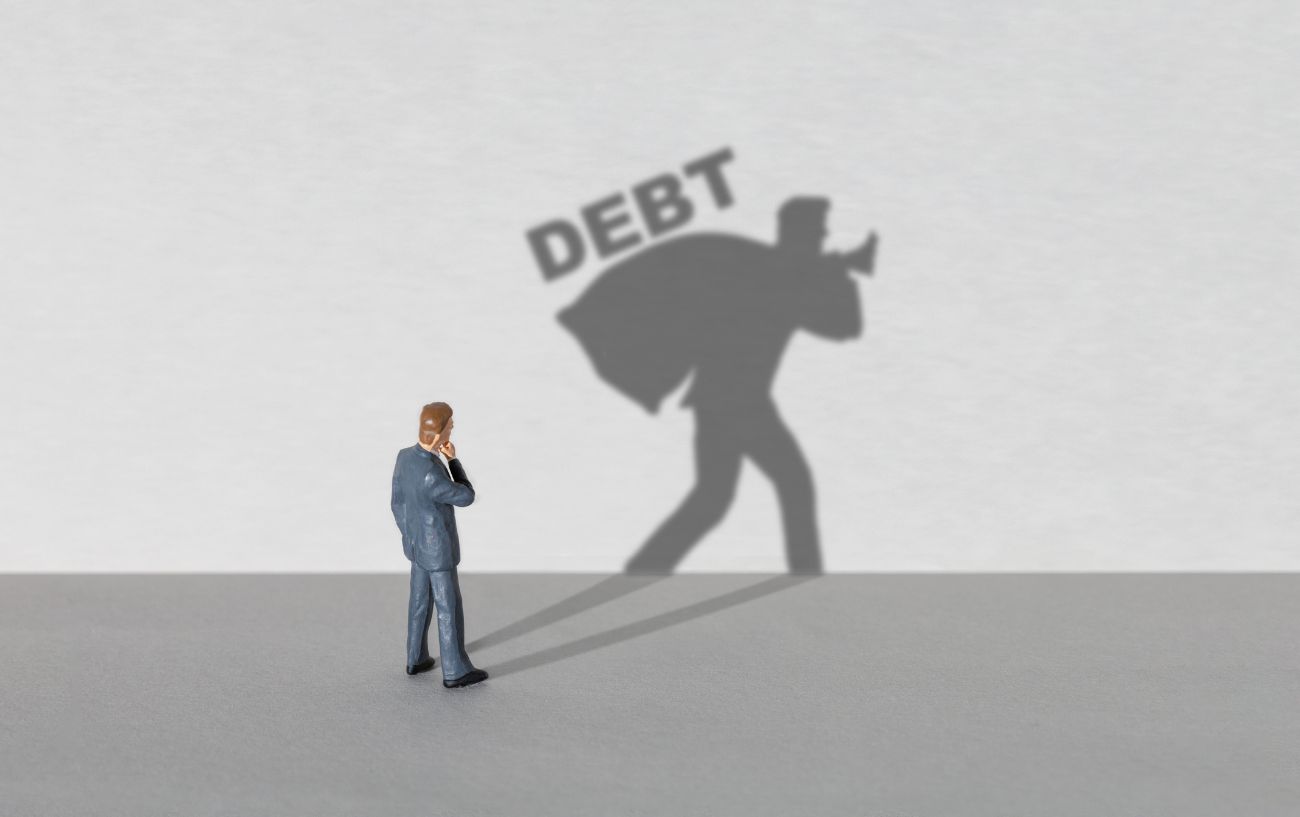 a figure of a man carrying debt