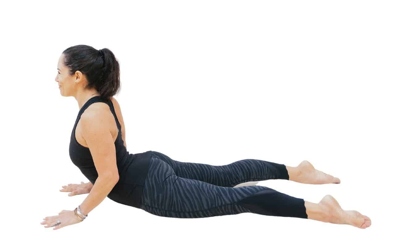 a photo of a woman wearing black yoga clothes doing Cobra pose