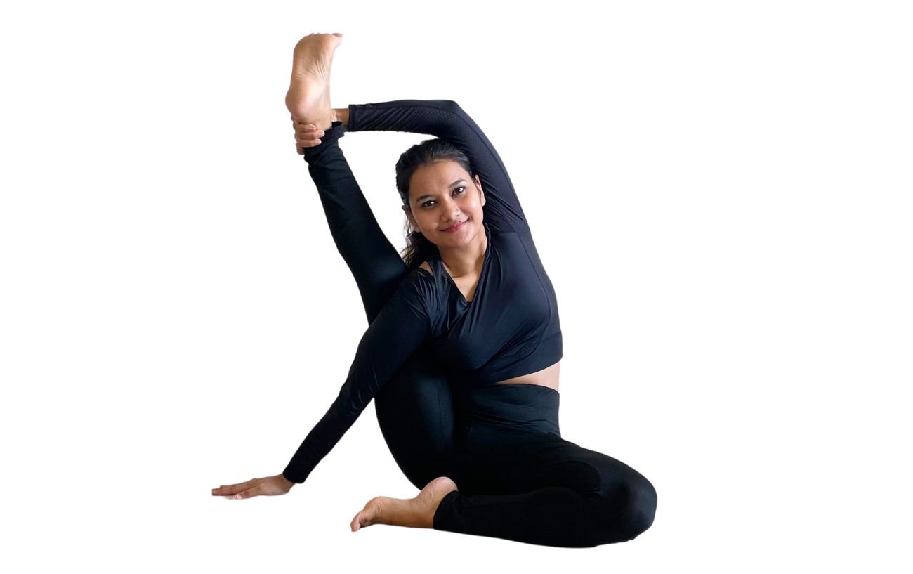 a woman wearing black yoga clothes doing compass pose