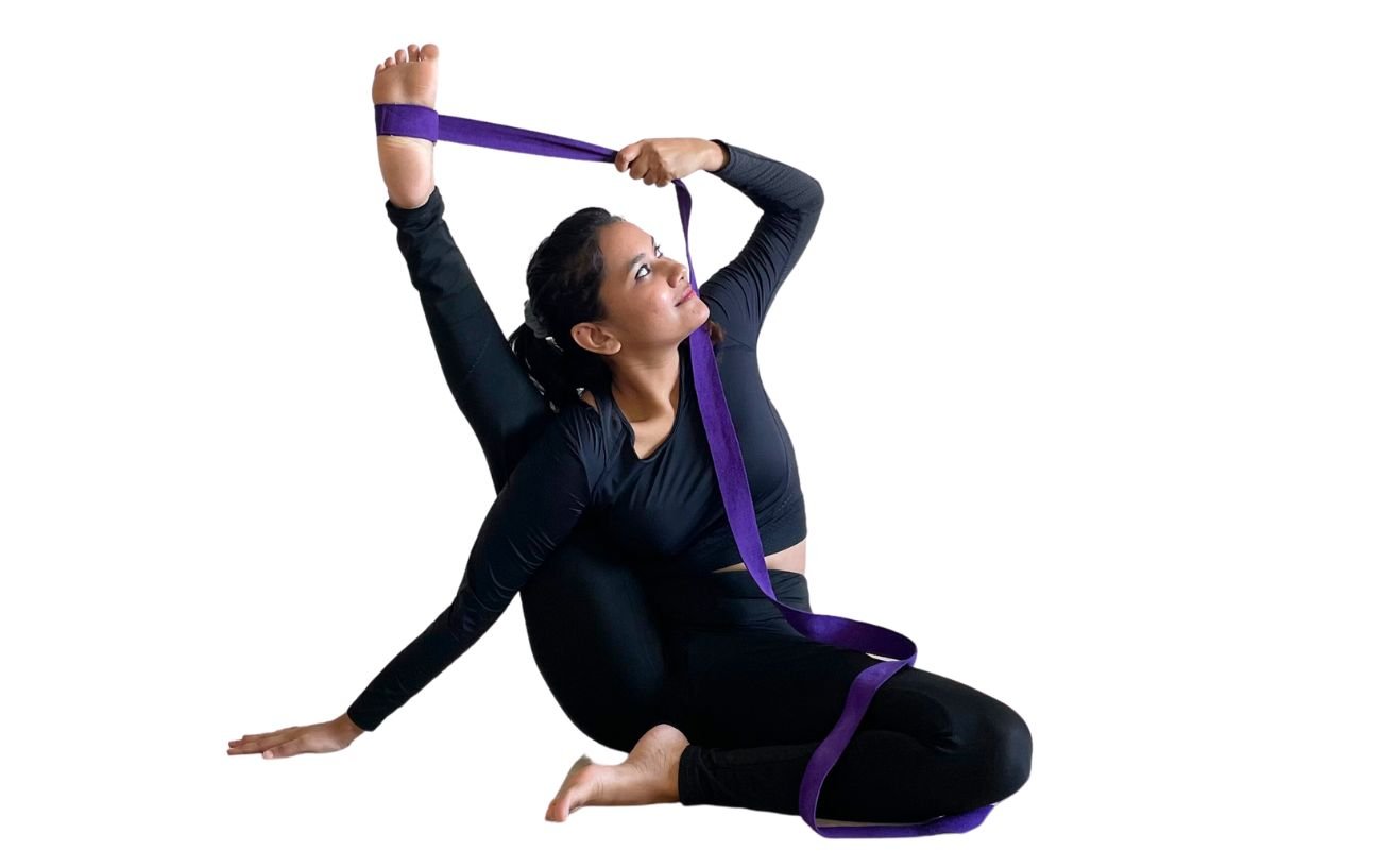 a woman wearing black yoga clothes doing compass pose with a purple strap