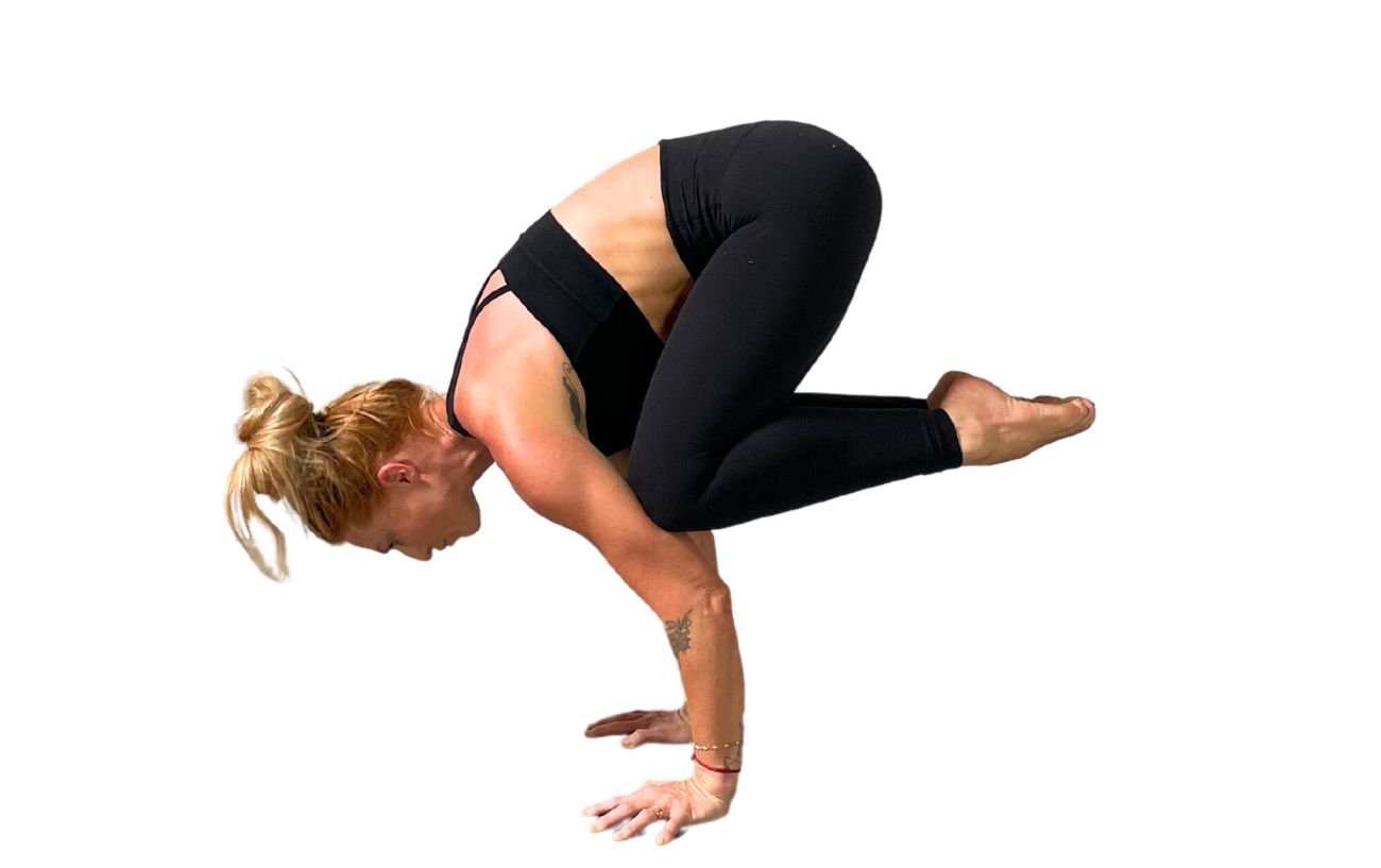 a woman wearing black yoga clothes doing crane pose