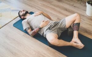 a man lying on his back on a yoga mat in bound angle pose