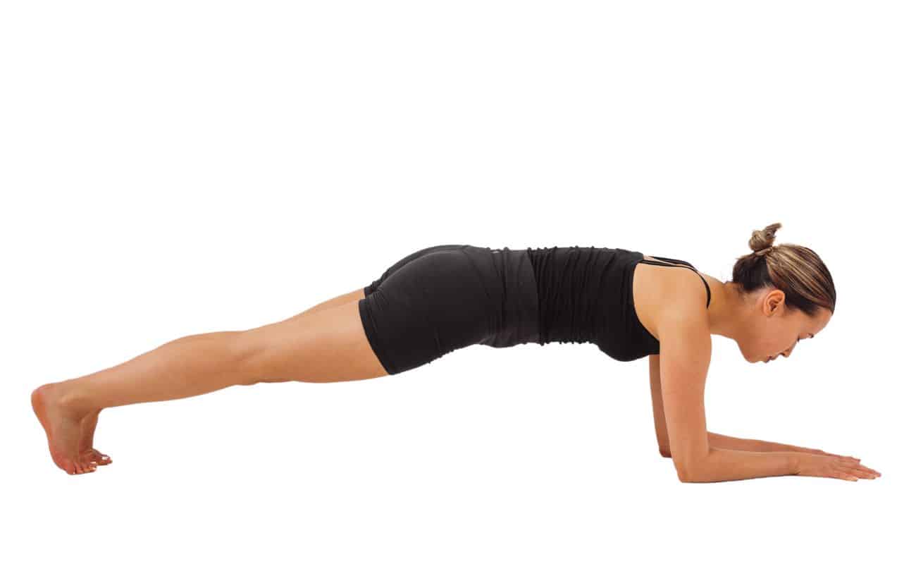 a woman wearing black yoga clothes doing a dolphin plank pose