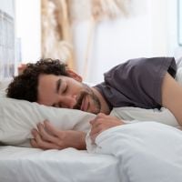 a man sleeping in white sheets