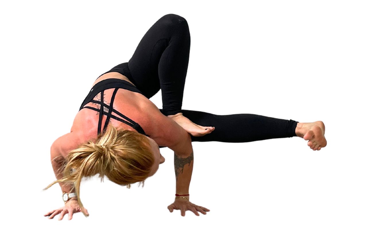 a woman wearing black yoga clothes doing dragonfly pose