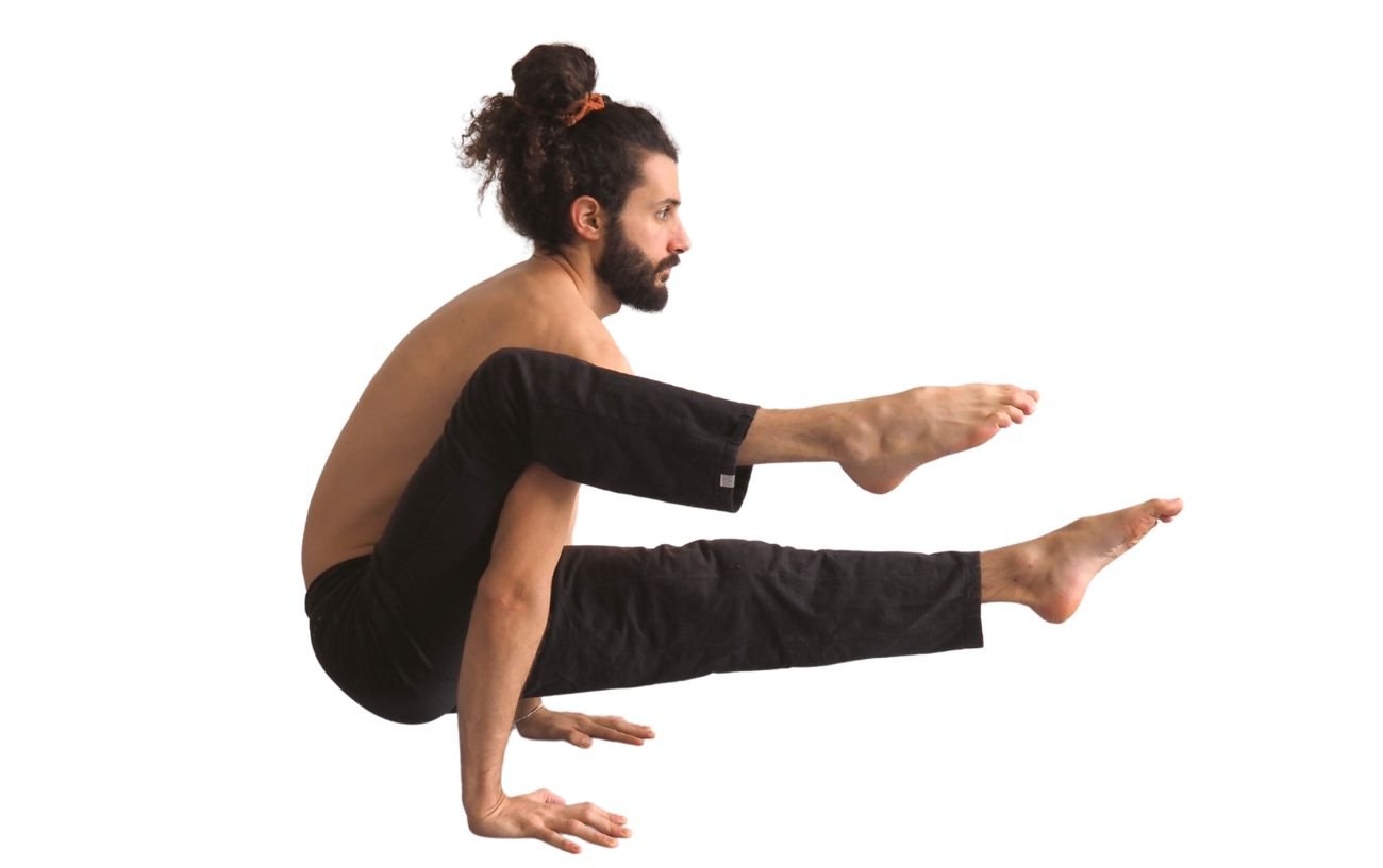 a man doing elephant trunk pose in black yoga pants