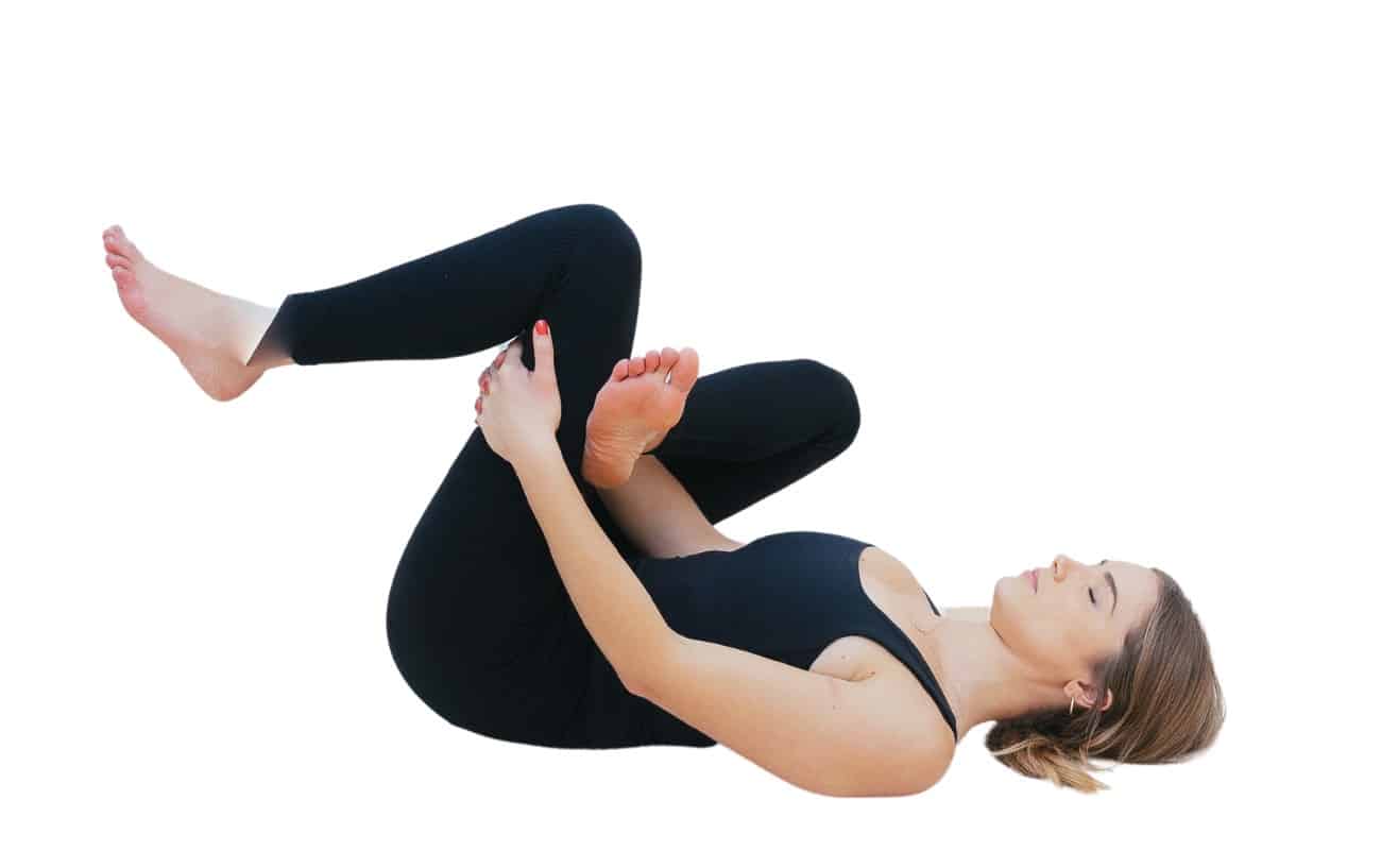 woman wearing black yoga outfit does a Reclining Pigeon Pose