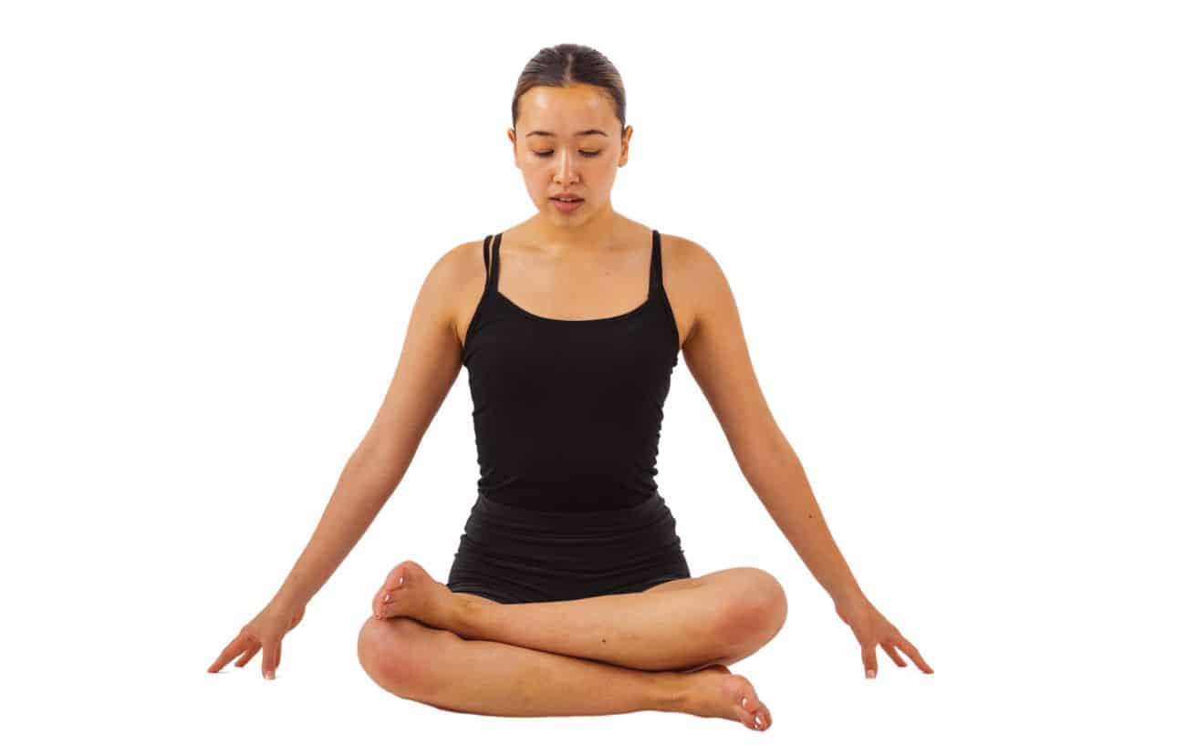 a woman wearing black yoga clothes doing fire log pose