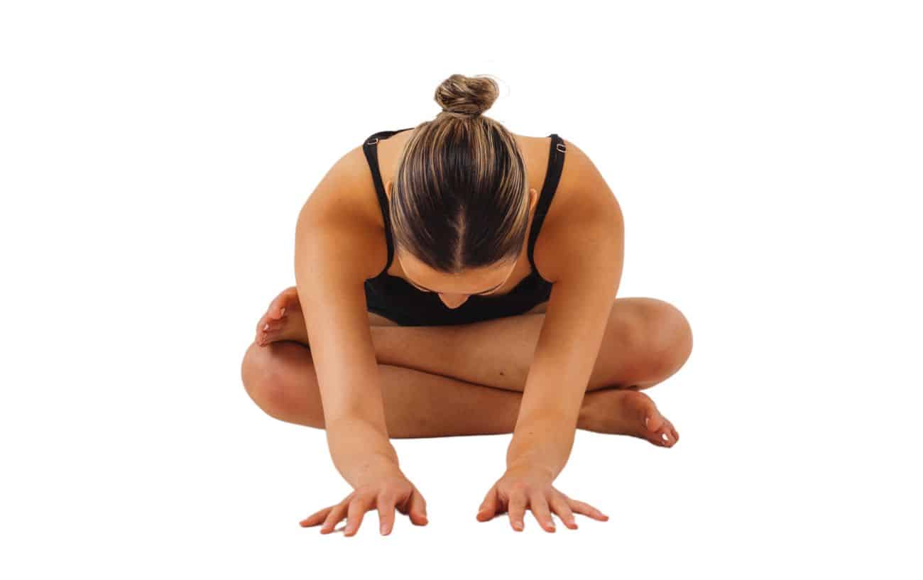 a woman wearing black yoga clothes doing fire log pose with her elbows on the floor