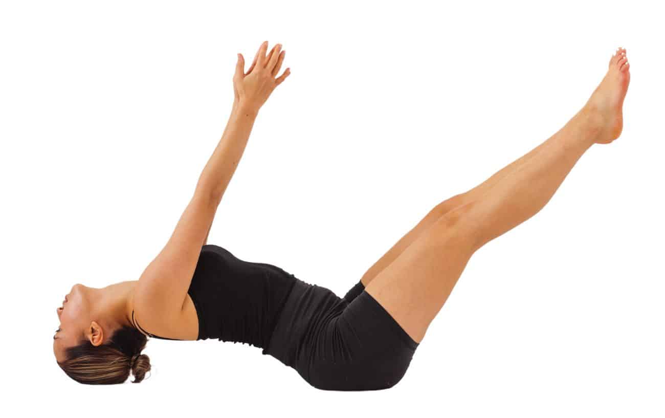 a woman wearing black yoga clothes doing fish pose with her legs and arms lifted