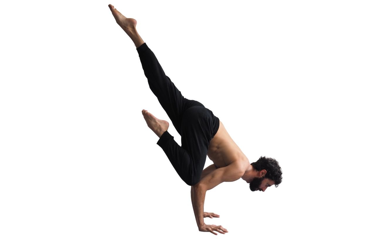 a man in black yoga trousers doing flying crow pose