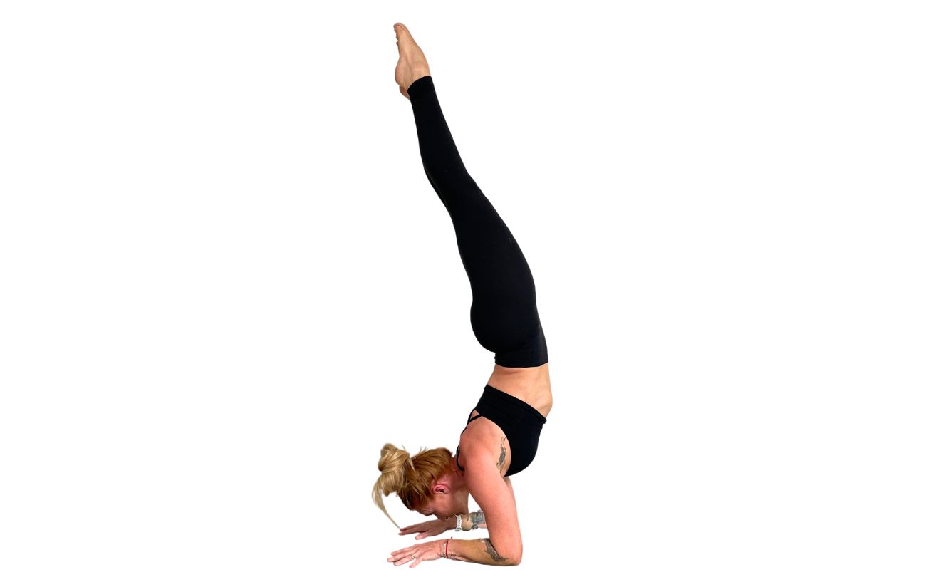 a woman wearing black yoga clothes doing forearm stand