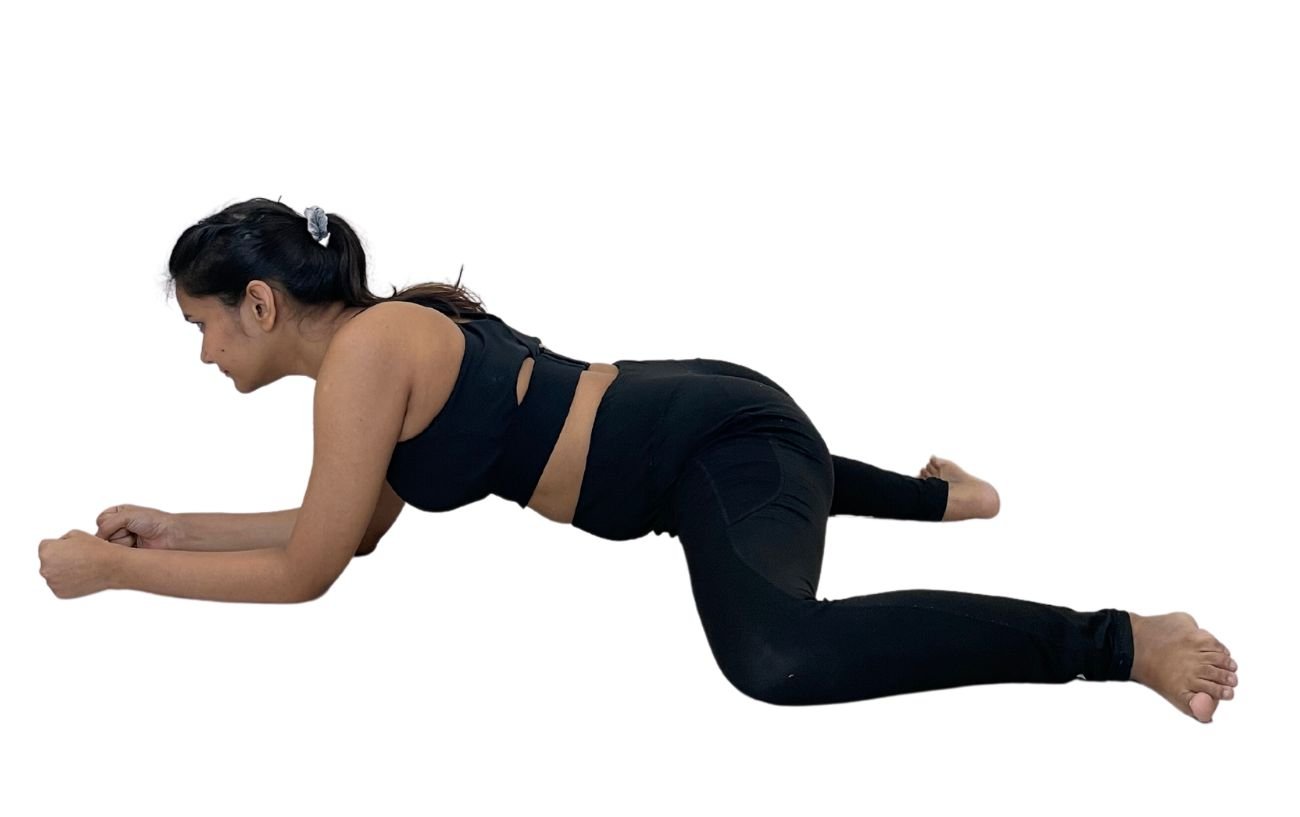 a woman wearing black yoga clothes doing frog pose