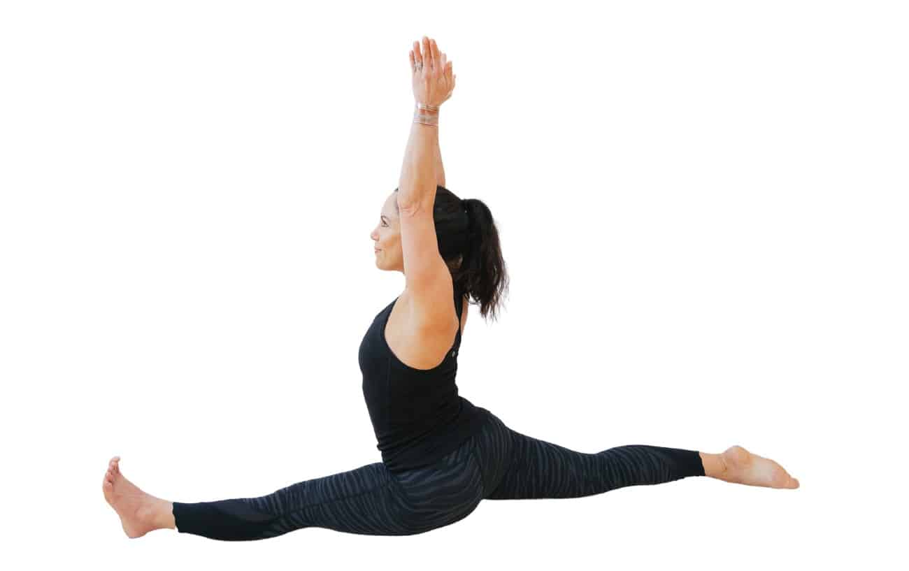 woman doing front split yoga pose with arms up