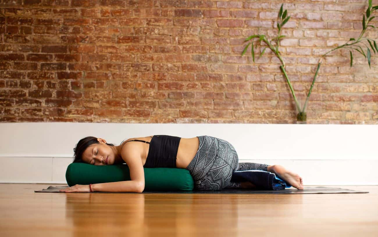 anwoman doing a restorative spinal gentle yoga pose