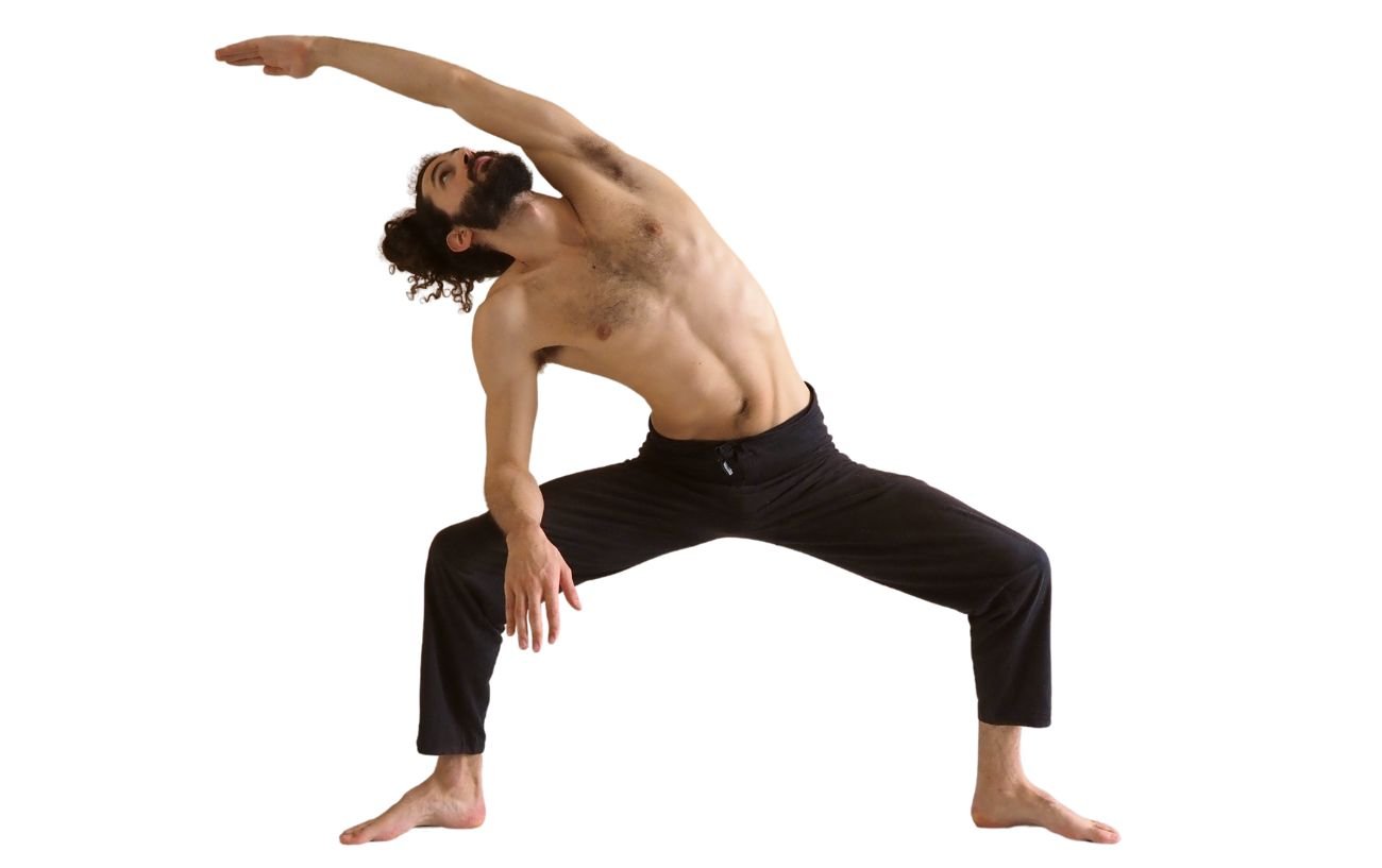 a man wearing black yoga trousers doing goddess pose with a side stretch